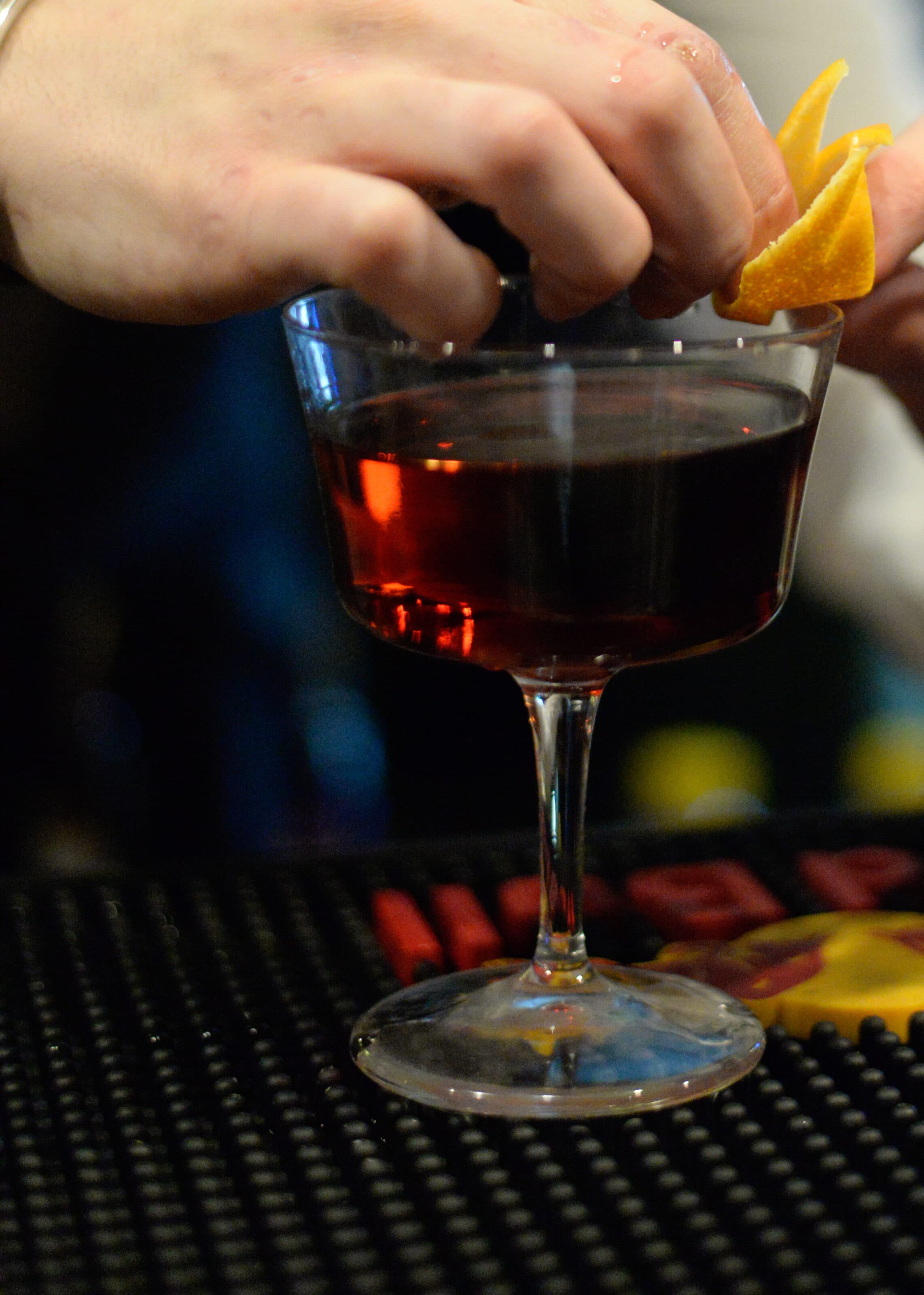 La scorza d'arancia sul cocktail, al bancone