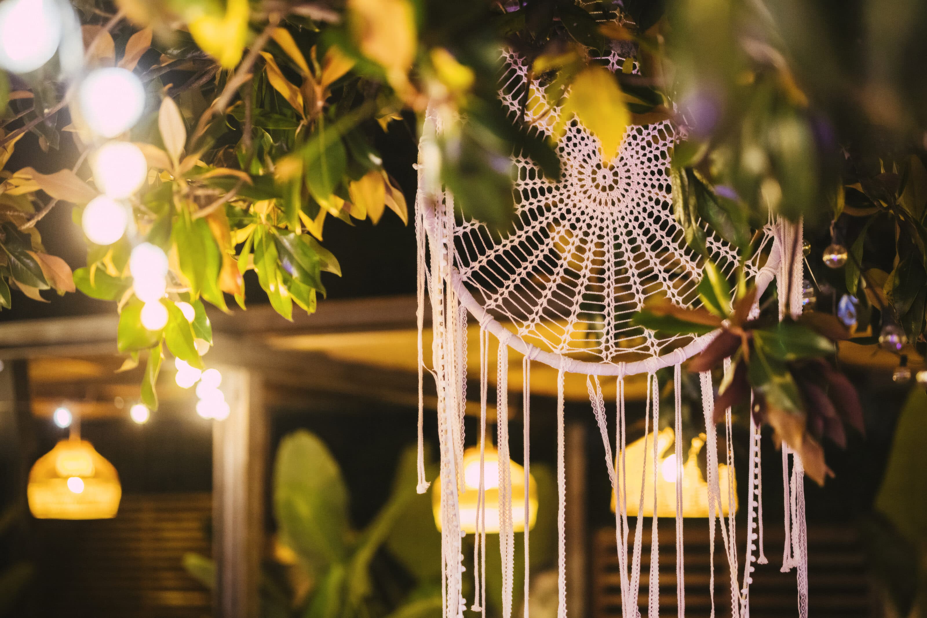 Un acchiappasogni tra le foglie e le luci del giardino