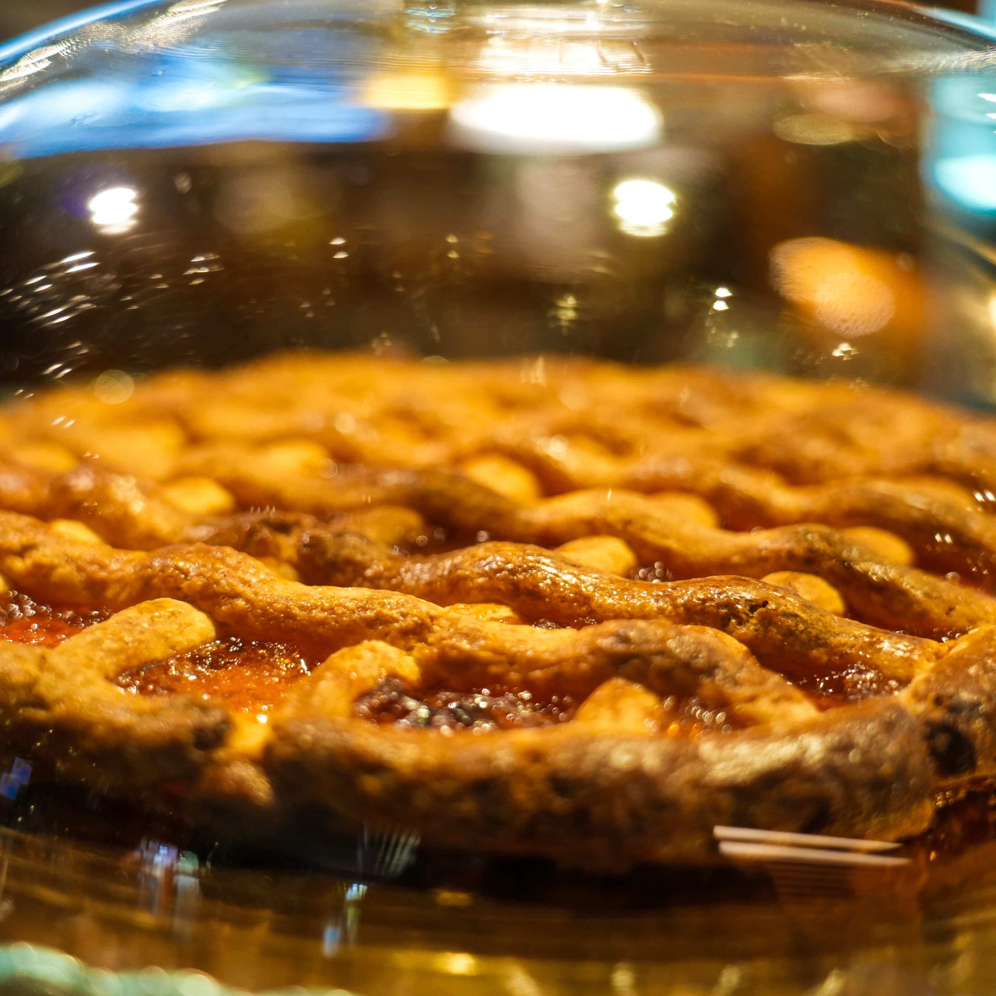 Una crostata con la grata sotto la campana di vetro