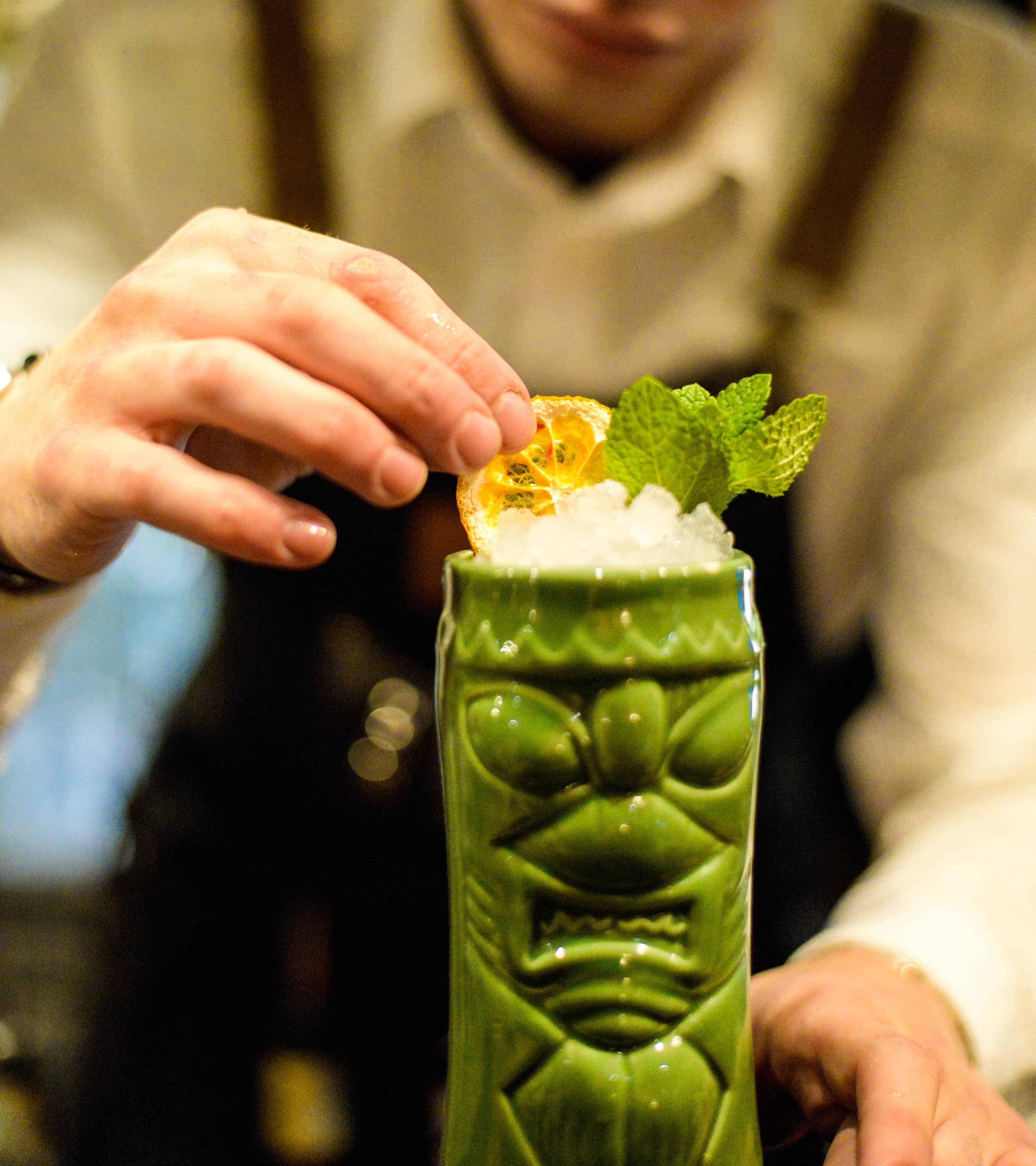 Un tiki con ghiaccio tritato, menta e arancia essiccata